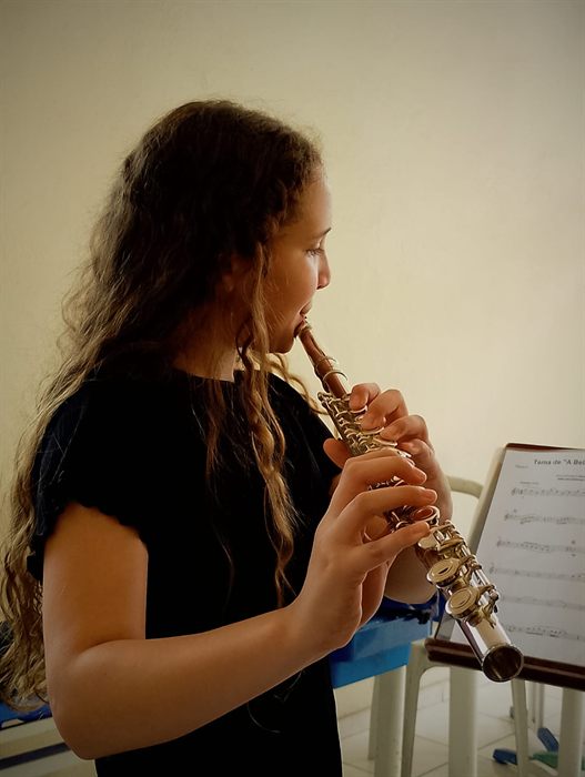 Aluna tocando clarinete na Escola de Música AdoraSom